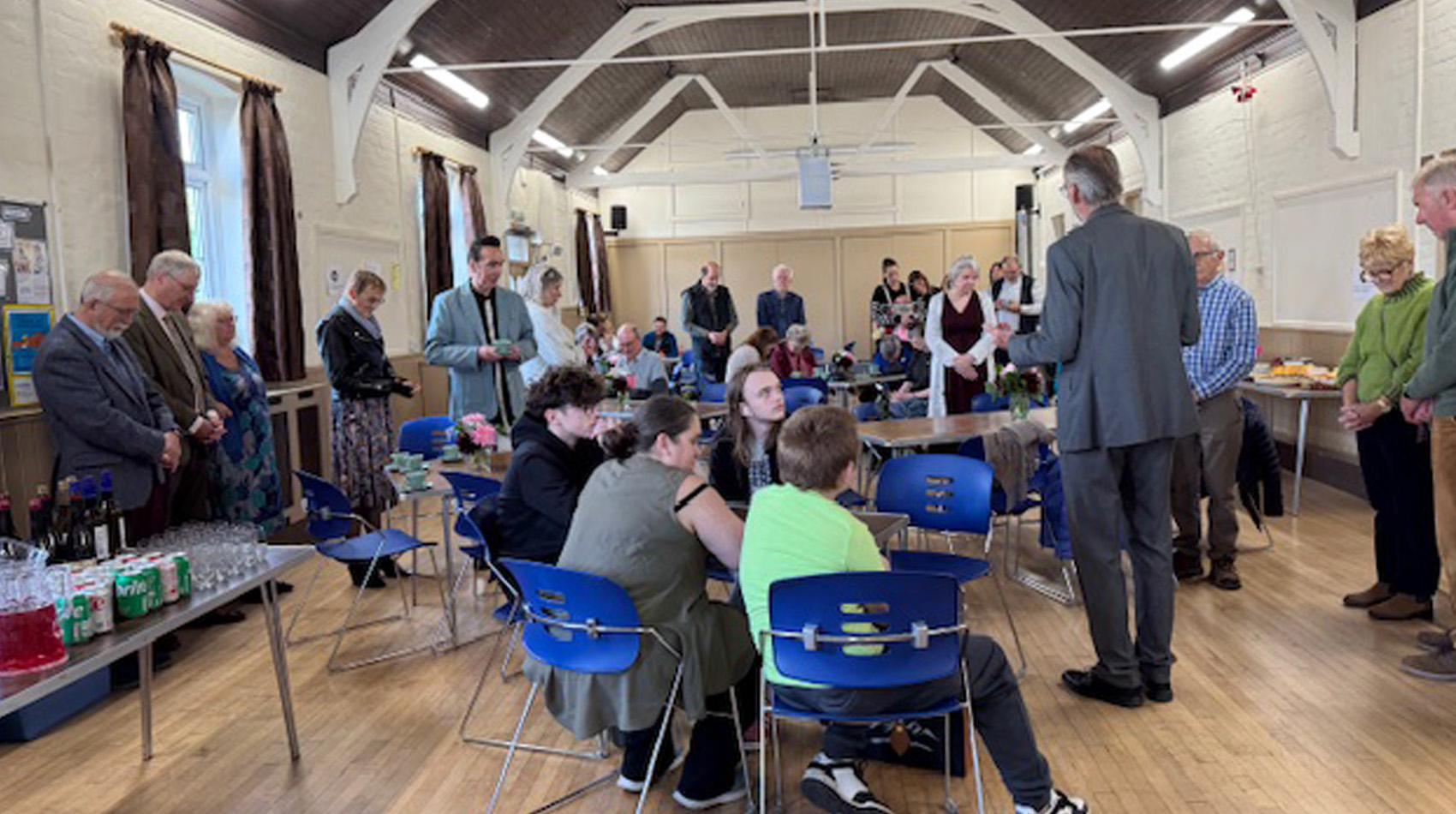 Church community gathering in parish hall with people socialising and refreshments